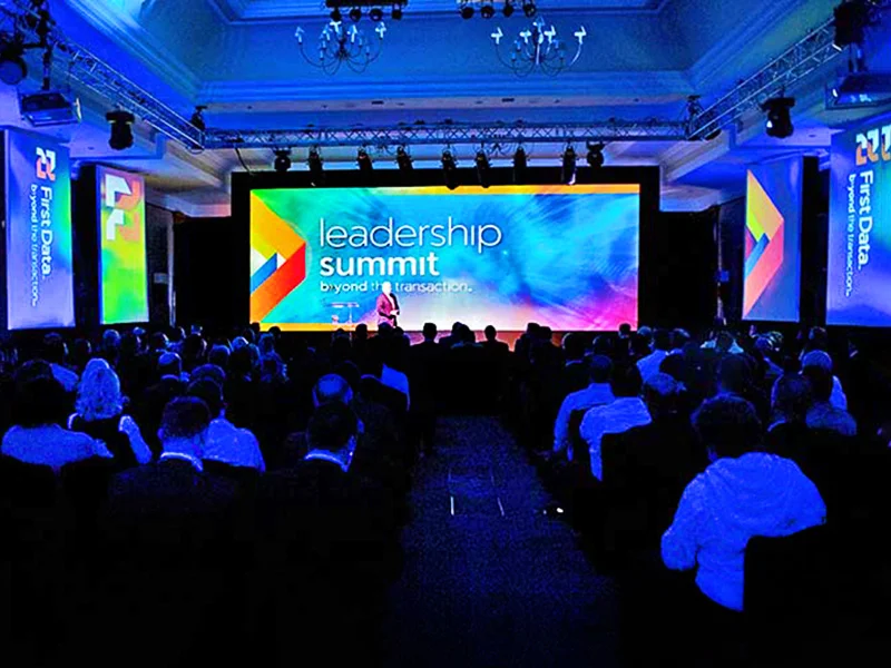 audience looking at large screen at corporate seminar